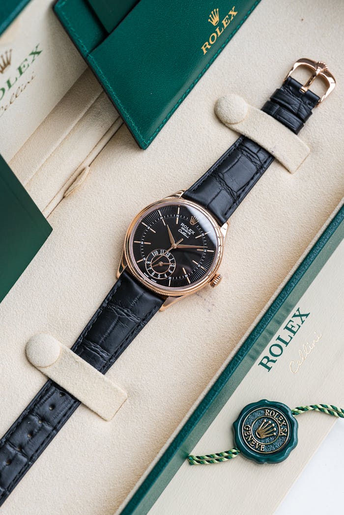 Elegant Rolex watch displayed in a luxury box with green accents and leather strap.
