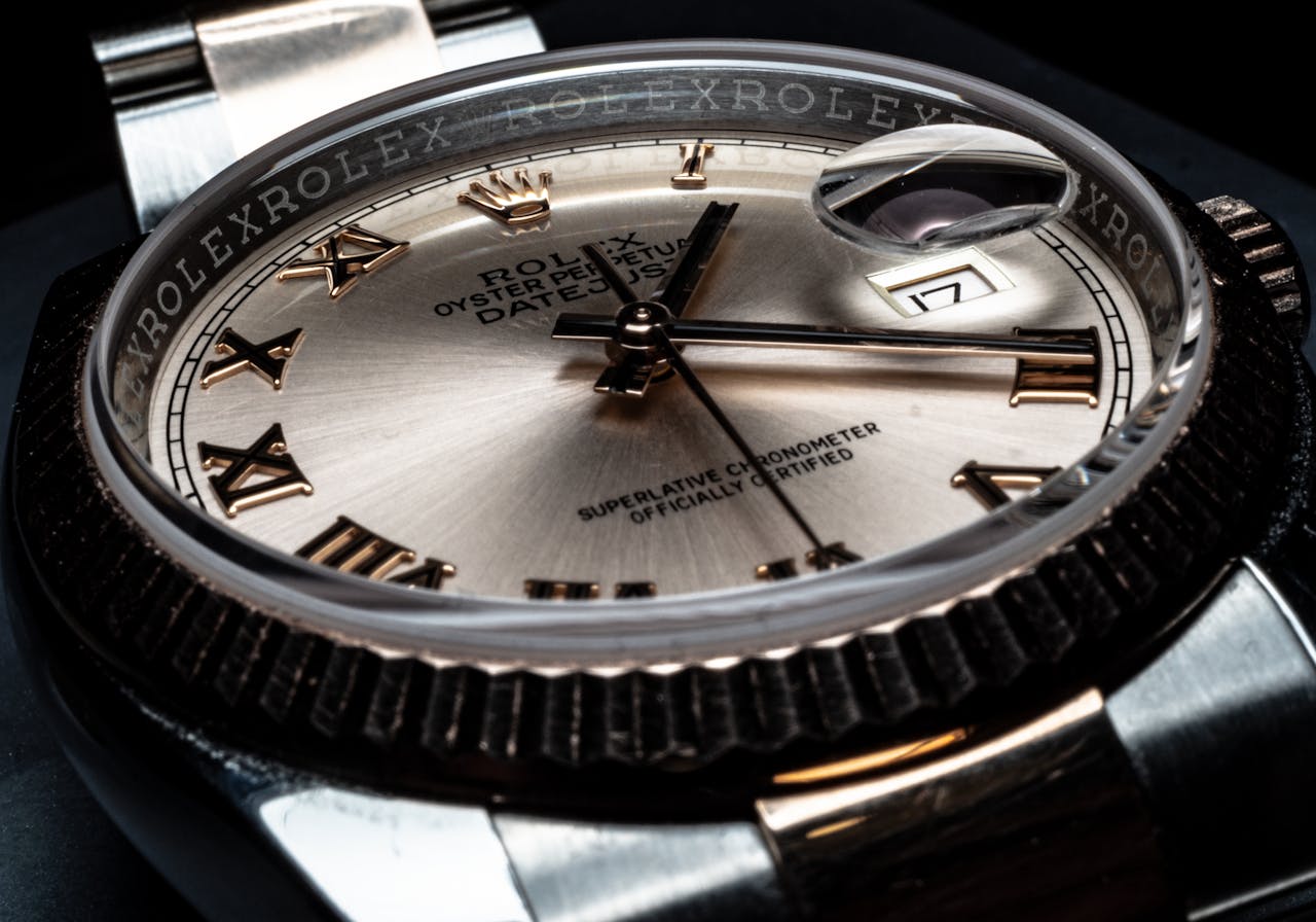 Detailed close-up of a luxury Rolex wristwatch displaying its elegant design and date feature.